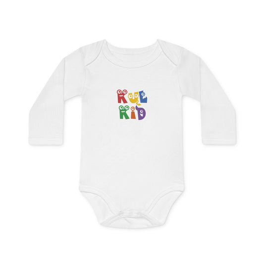 Baby iført hvit body med monster-motiv fra KUL KID, sittende på lys bakgrunn
