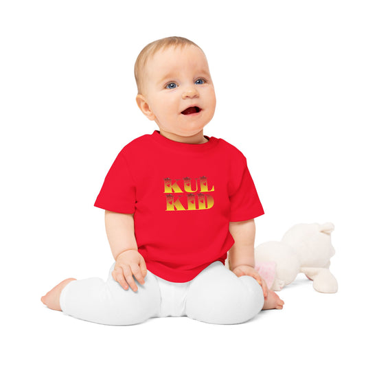 Baby iført KUL KID Solspøkelse-t-skjorte i rød variant, sittende på lys bakgrunn.