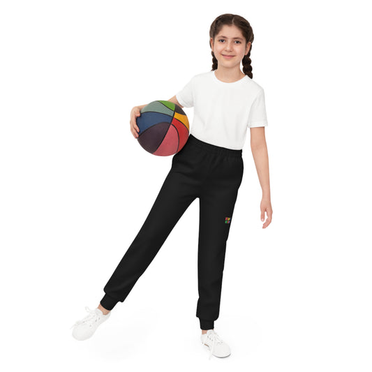 Barn iført svart joggebukse fra KUL KID Basics, med basketball i hånden.