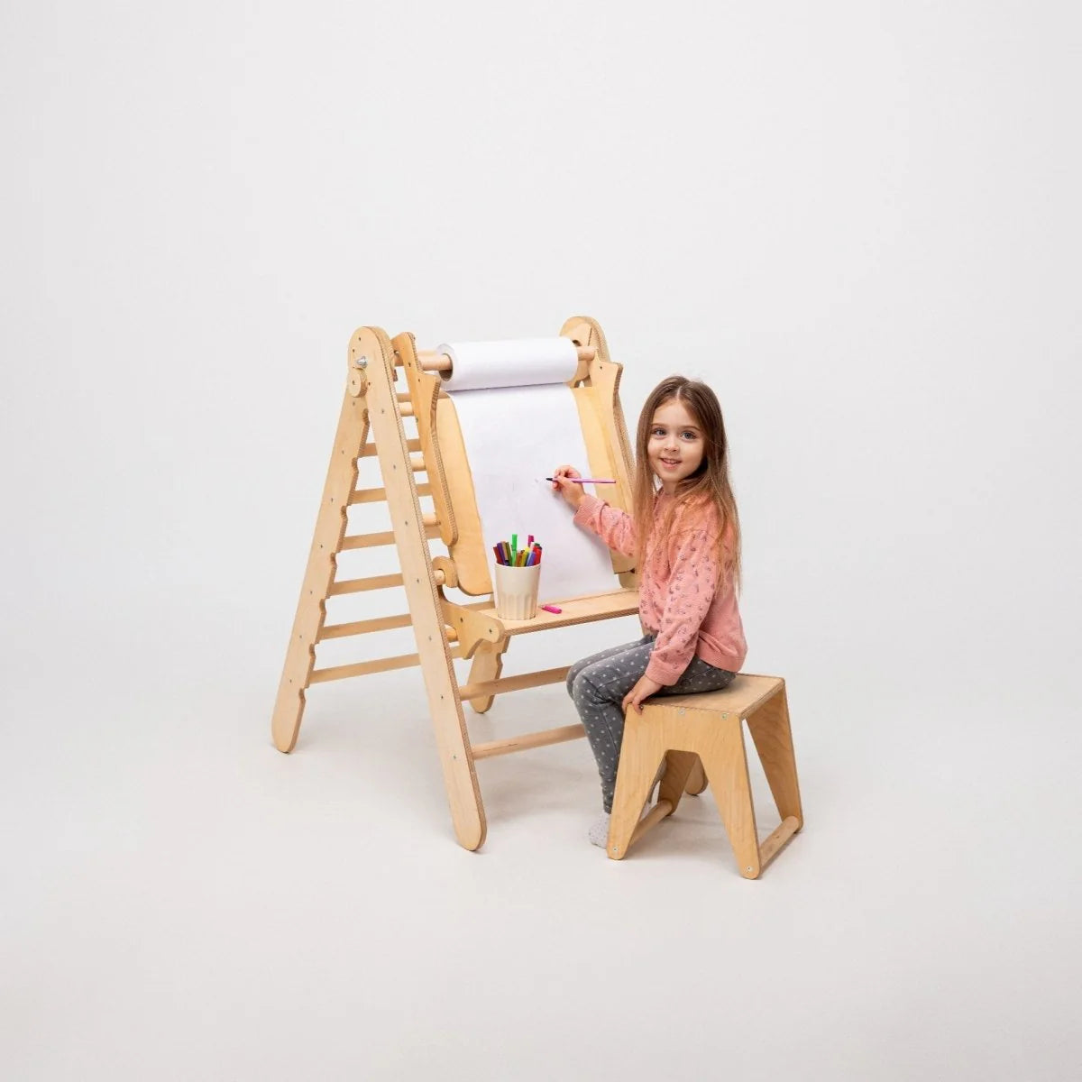 Barn tegner på kunsttillegg montert på Montessori trekantstige – kreativ lek hjemme
