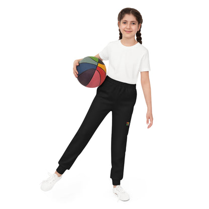 Barn iført svart joggebukse fra KUL KID Basics, med basketball i hånden.